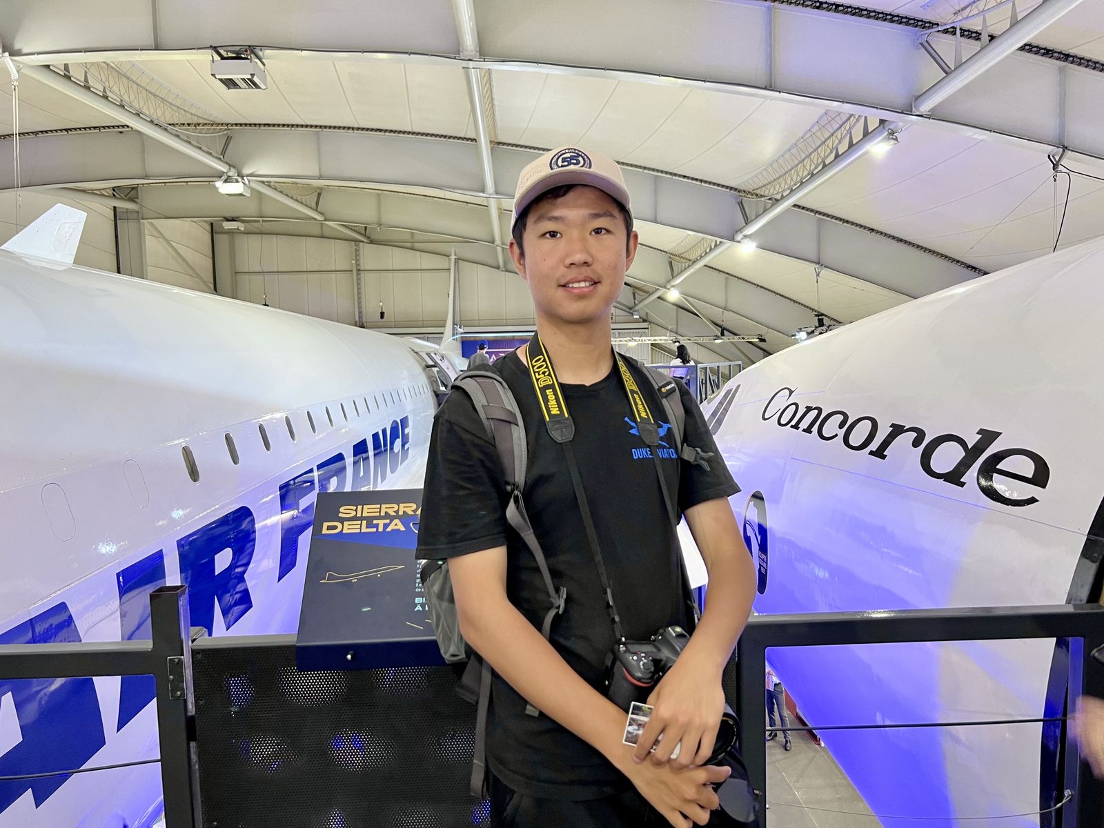 Thomas standing between an Air France Concorde and another aircraft inside a hangar